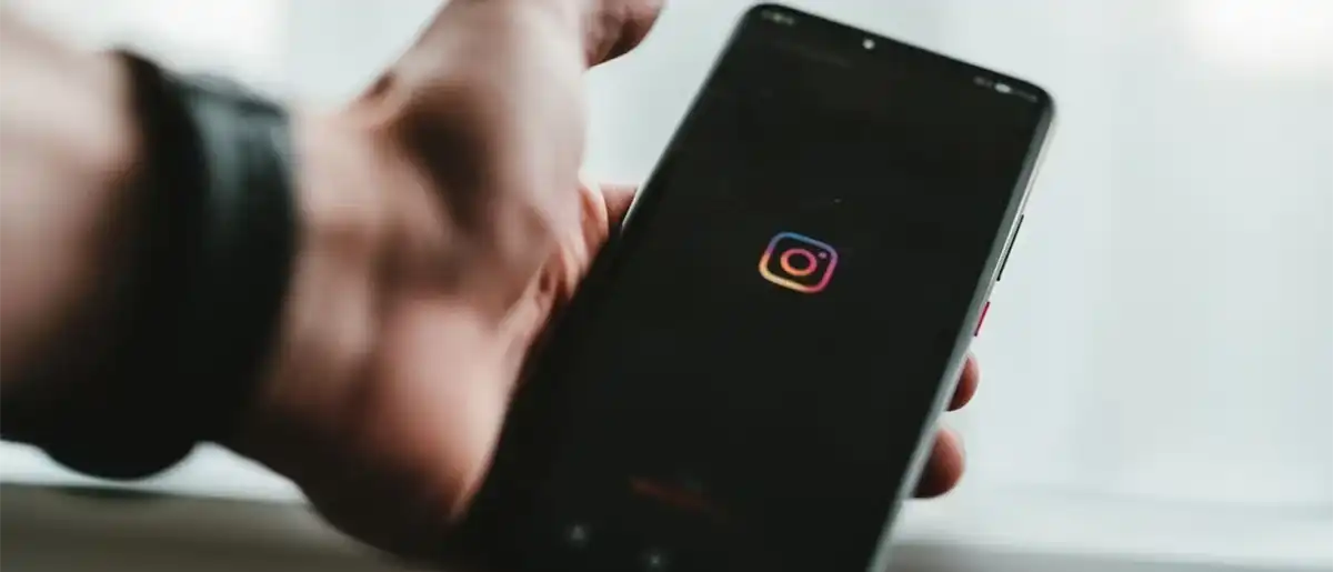 Person-holding-phone-using-Instagram
